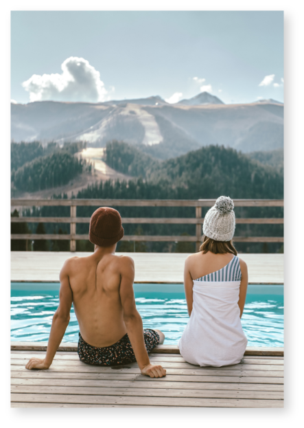 Man and woman gazing at mountains while at a hot springs near Invermere
