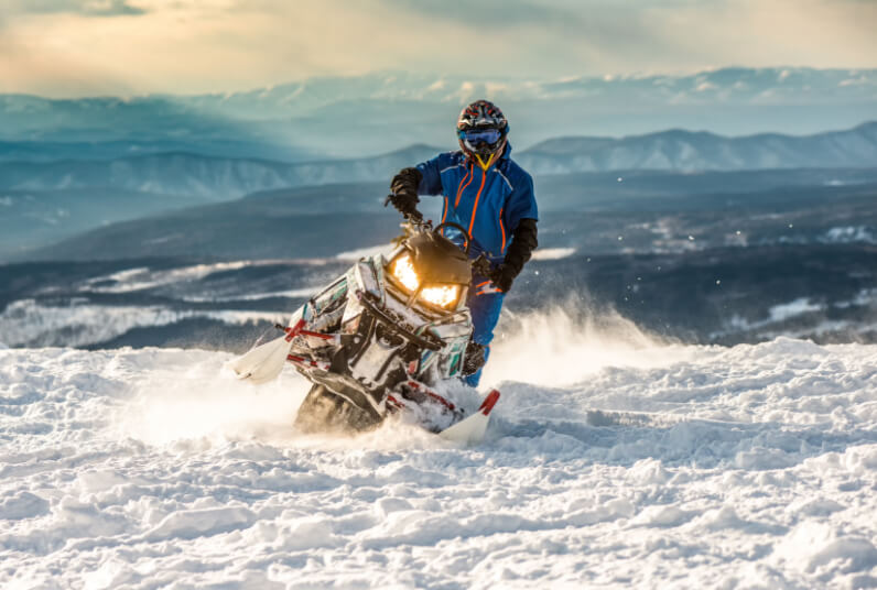 Snowmobiler riding up a mountian in the Columbia Valley