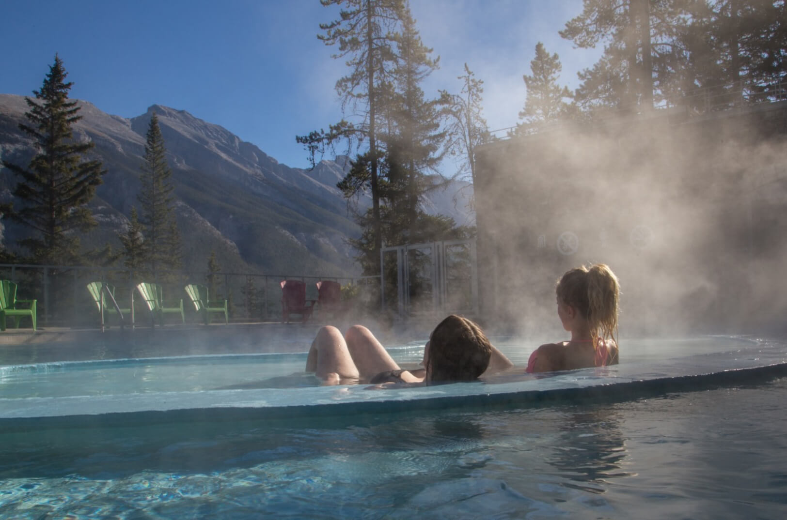 Two girls enjoying Radium Hot Springs with a view of surrounding mountains